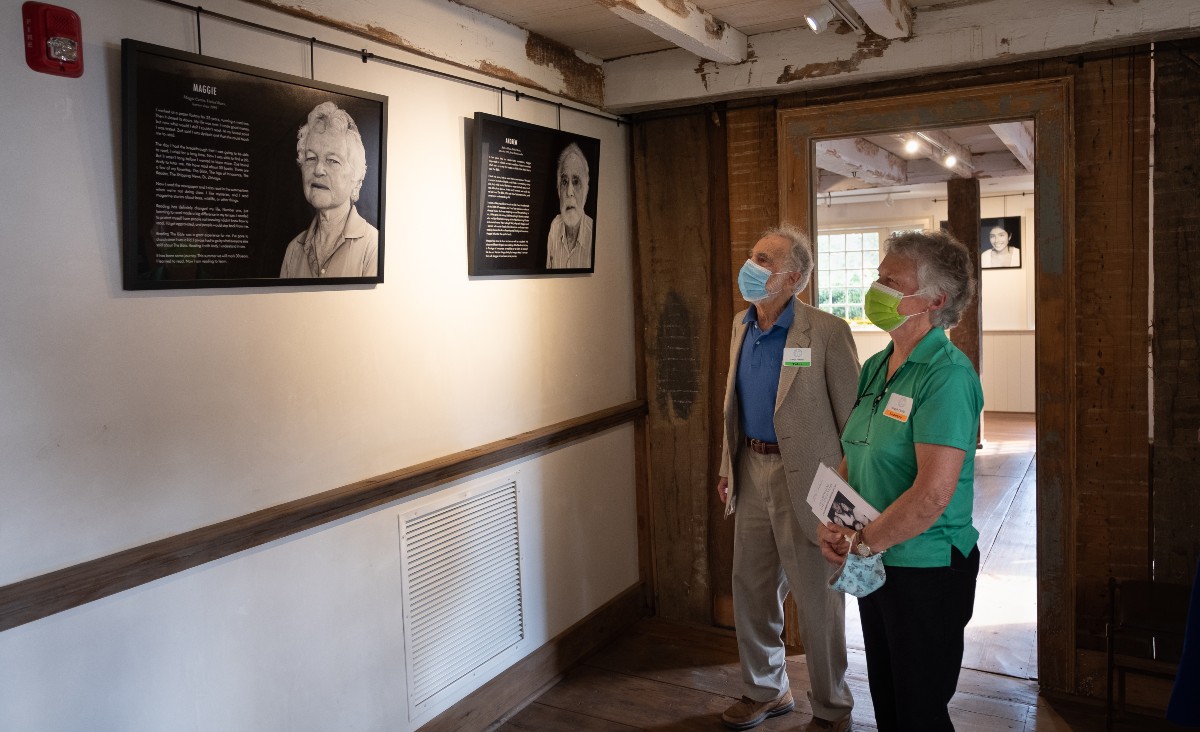 Andy Pincus, a LitNet tutor, and Maggie Curtin, his learner, in front of their photographs, part of the "Transforming Live for 30 Years" exhibit