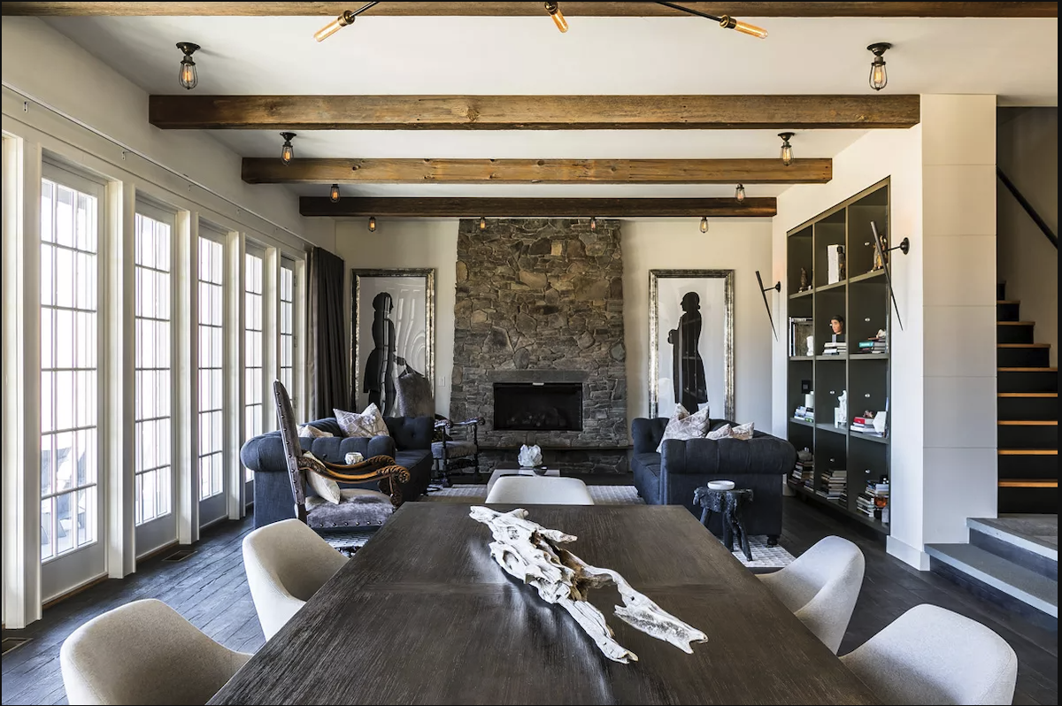 
Running along the back of the home, the dining and living areas face the lake. To contrast the rough stone fireplace, Stabilito added a collection of soft seating and a modern metal bookcase. “I was going for a mix of American Colonialism and old artifacts, but with a modern spirit,” he explains. Stabilito created the fireside silhouette portraits from original 18th-century prints. After enlarging the portraits, he traced them onto black paper, then framed the enlarged cutouts. - Winona Barton-Ballentine
Running along the back of the home, the dining and living areas face the lake. To contrast the rough stone fireplace, Stabilito added a collection of soft seating and a modern metal bookcase. “I was going for a mix of American Colonialism and old artifacts, but with a modern spirit,” he explains. Stabilito created the fireside silhouette portraits from original 18th-century prints. After enlarging the portraits, he traced them onto black paper, then framed the enlarged cutouts. - Winona Barton-Ballentine