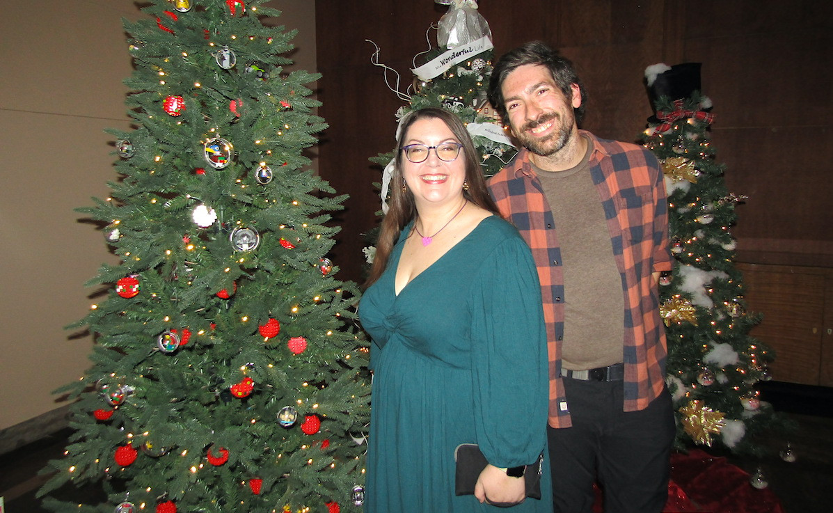 Erin Laundry of Bottomless Bricks poses in front of her Lego-decorated tree with friend James Grady.