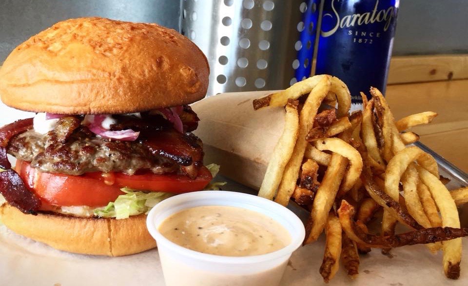 A burger, fries, and extra sauce