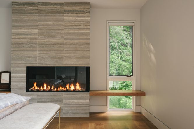 The use of natural materials &mdash; wood, stone, and glass &mdash; help integrate the home into its sylvan surroundings.