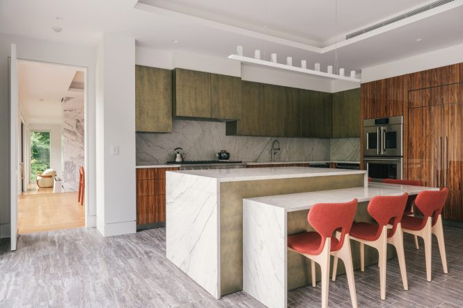The visual texture of black travertine tiles on the kitchen floor pairs nicely with polished white quartzite countertops.
