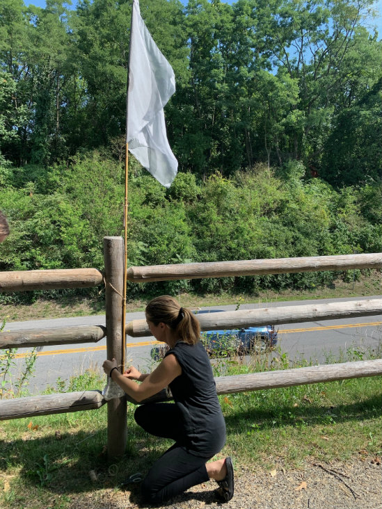 Filiz Soyak installs a flag along the Hudson River Skywalk.
