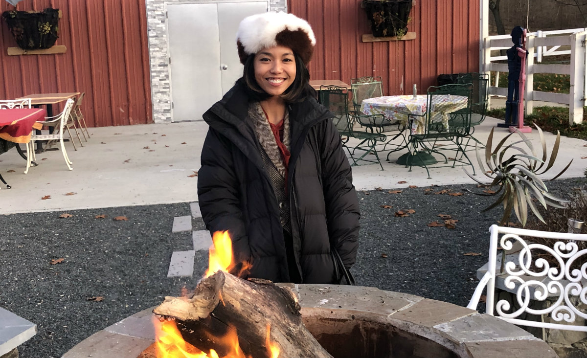 Style blogger Kate Greer, visiting from Washington, D.C., warms up by the courtyard fire.