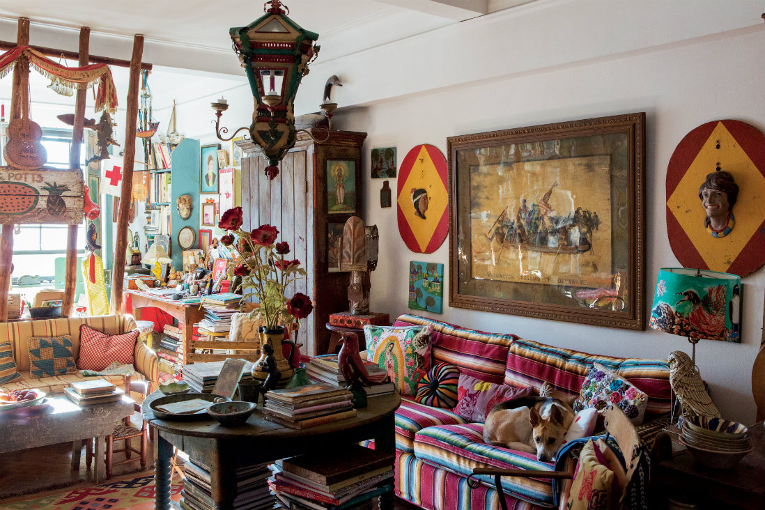 How Mary Randolph Carter lives: "In our living room, the trap stake partition divides the sitting and work areas. The serape-covered sofa is camouflaged with a collection of pillows and our grand-dog Cora. A pair of 3-D carnival plaques flank an embroidered interpretation of Washington Crossing the Delaware inspired by Emanuel Leutze&#39;s famous painting."