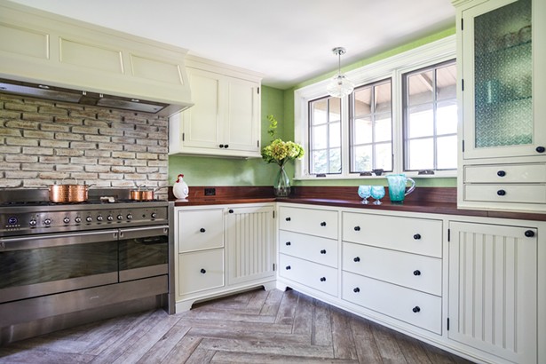 The house&rsquo;s original woodstove (it&rsquo;s now in Jackson&#39;s carpentry shop) was replaced with a stainless steel six-burner stove. The kitchen is finished in African ribbon-striped sapele wood on the counters and pantry cabinets. Jackson added the south-facing window over the counter. &ldquo;It really brings the outside inside,&rdquo; he says.