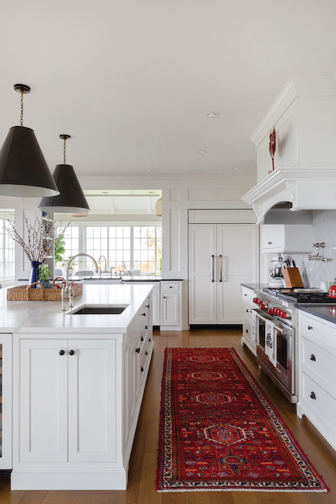 Harwood’s approach to trim, consistent throughout the house, lends itself to a streamlined flow as evidenced in the airy kitchen. Ample space for the cook — with easy access to the commercial range, farmhouse sink, and cabinet-paneled refrigerator — is balanced by an equally wide passage for traffic (and access to the outdoor, screened-in dining area). Harwood’s approach to trim, consistent throughout the house, lends itself to a streamlined flow as evidenced in the airy kitchen. Ample space for the cook — with easy access to the commercial range, farmhouse sink, and cabinet-paneled refrigerator — is balanced by an equally wide passage for traffic (and access to the outdoor, screened-in dining area).