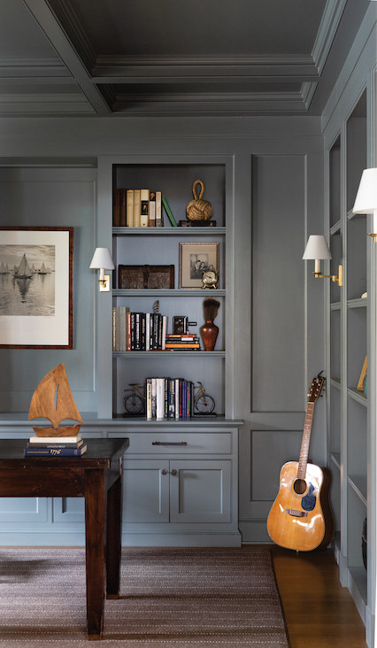 This office, one in a pair flanking the great room’s massive stone fireplace, serves as a retreat. Both intrigue and intimacy are achieved via intentional details like custom millwork, a tray ceiling, and built-ins, all drenched in the same deep tone to create the cozy effect of a cocoon. Occasional nods to the sea, equally evident in collectibles and wall art, harken back to the Nantucket-style home the clients envisioned. This office, one in a pair flanking the great room’s massive stone fireplace, serves as a retreat. Both intrigue and intimacy are achieved via intentional details like custom millwork, a tray ceiling, and built-ins, all drenched in the same deep tone to create the cozy effect of a cocoon. Occasional nods to the sea, equally evident in collectibles and wall art, harken back to the Nantucket-style home the clients envisioned.