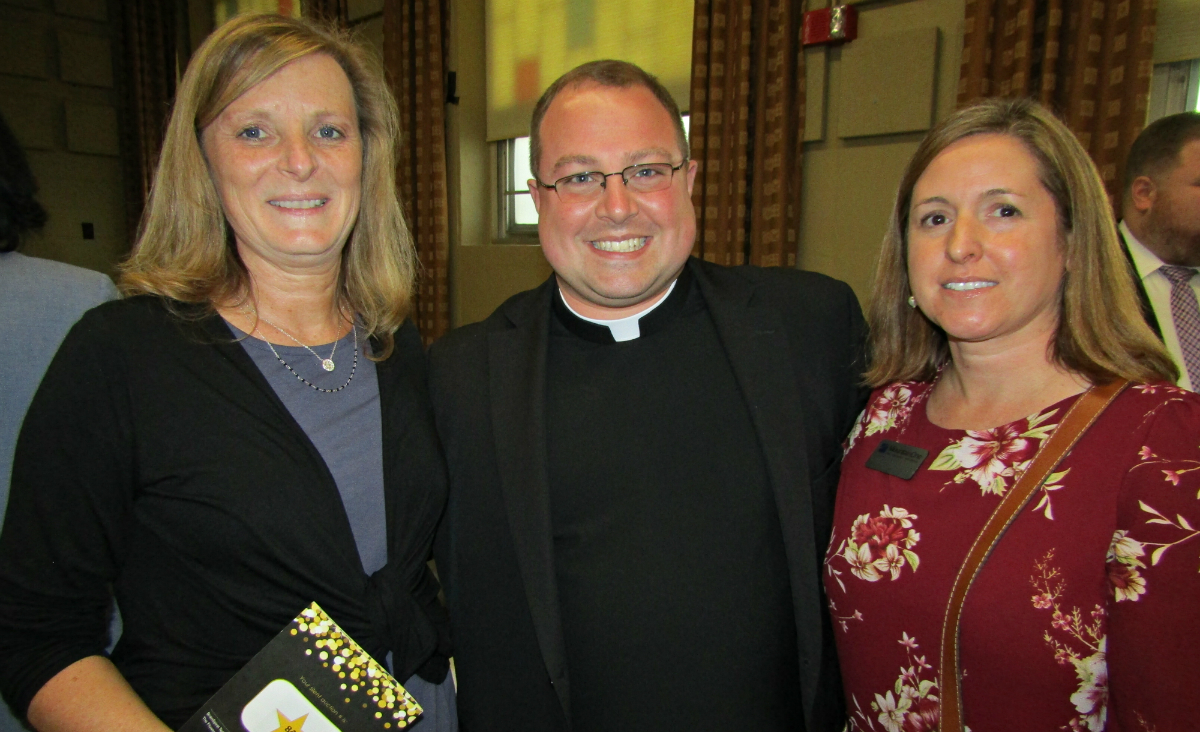 Lisa Mineau&nbsp;and&nbsp;Beth Petropulos&nbsp;of MountainOne flank&nbsp;Father Matt Alcombright.