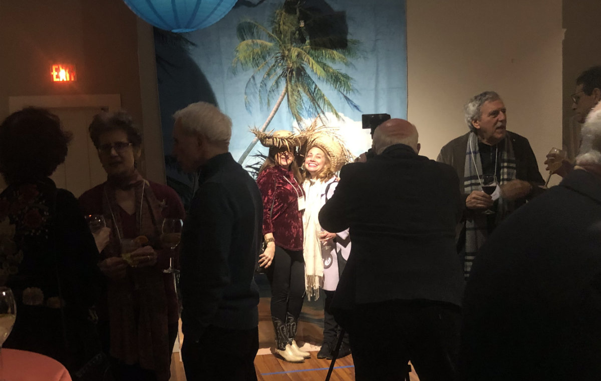 Gerald Seligman creates a photo memento as guests get playful with props against a tropical background.