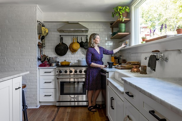 Kathy Reisfeld in the home’s new kitchen, which had been badly damaged by flooding before the couple bought the home. With the help of architect Inma Donaire, they reimagined the space to include a modern rectangular window capturing the arboreal view. “The home feels like it has its own life to it,” explains Reisfeld. “It feels like we are just custodians of this place for a while.” Kathy Reisfeld in the home’s new kitchen, which had been badly damaged by flooding before the couple bought the home. With the help of architect Inma Donaire, they reimagined the space to include a modern rectangular window capturing the arboreal view. “The home feels like it has its own life to it,” explains Reisfeld. “It feels like we are just custodians of this place for a while.”