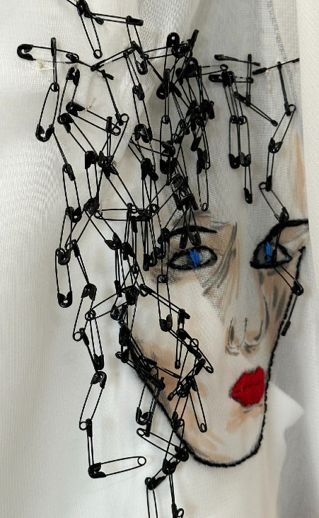 Breen hand painted this dramatic piece, which is adorned with small, black safety pins, as part of a special collection she designed to address mental health.&nbsp;